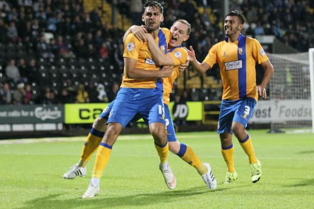 RyanTafazolli is mobbed after scoring for Mansfield. Photo: Richard Parkes.