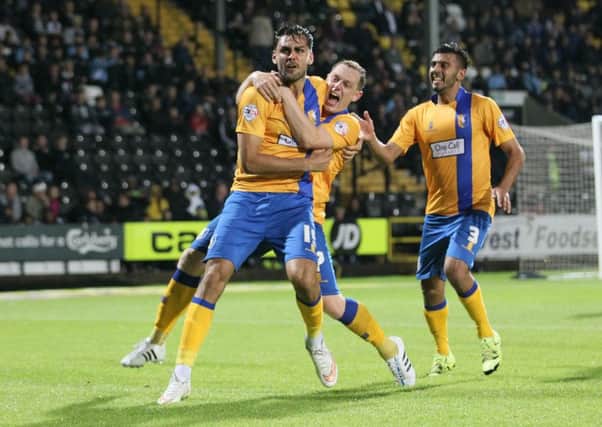 RyanTafazolli is mobbed after scoring for Mansfield. Photo: Richard Parkes.