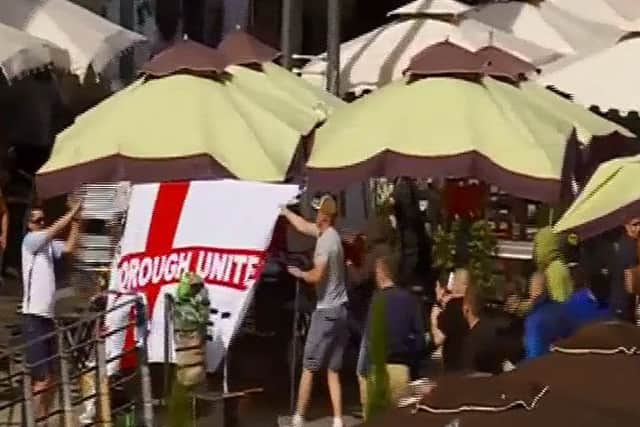 The Peterborough United flag being ripped down by Russian fans. Credit: BBC