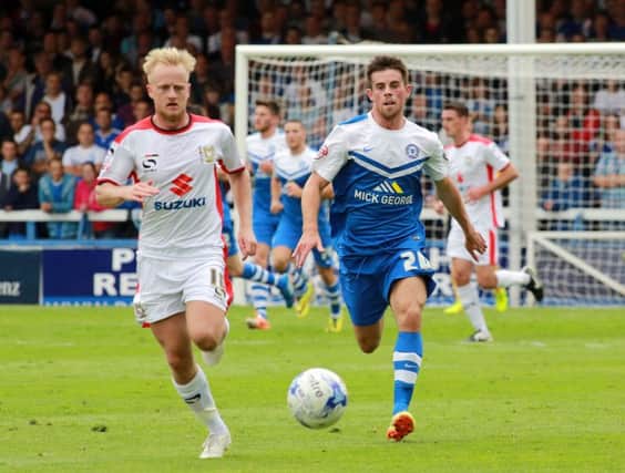 Kenny McEvoy (right) in action for Posh against MK Dons.