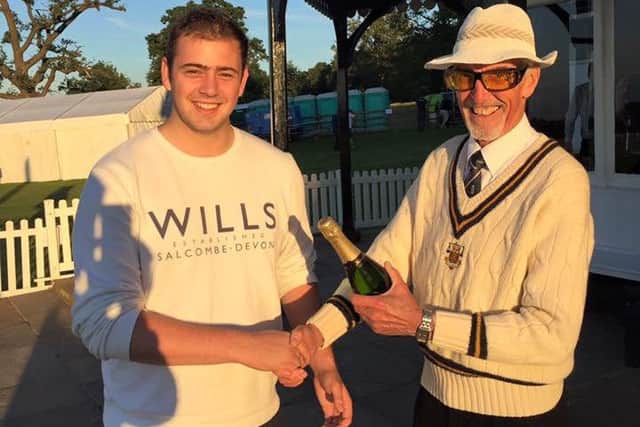 Ufford Park's Joe Harrington receives his 'champagne moment' prize from umpire Derek Patience.
