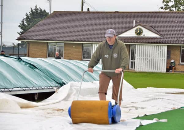 Market Deeping skipper Dave Gillett helps to make the Outgang Road pitch playable for the visit of Grimsby. Photo: Tim Wilson.