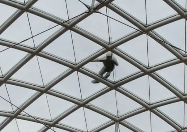 Isaac Moore, 27 on the glass roof of the Grand Arcade shopping centre