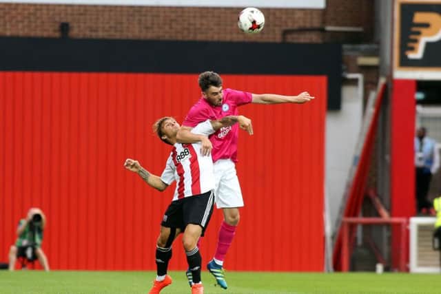 Posh full-back Michael Smith wins this header in the friendly game at Brentford. Photo: Joe Dent/theposh.com.