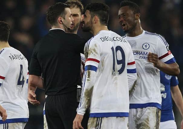 Referee Michael Oliver is surrounded by Chelsea players.