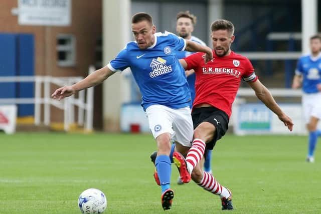 Posh striker Paul Taylor tries to fend off Barnsley misfielder Conor Hourihane. Photo: Joe Dent/theposh.com.