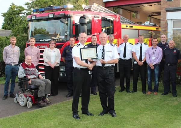 Chief Fire Officer Chris Strickland presented David Killner with a certificate and glass flame award to mark his 40 years service