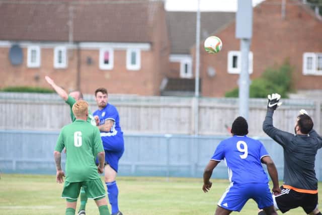 Josh Moreman (blue, winning header) claimed a hat-trick for Peterborough Sports at Harborough.