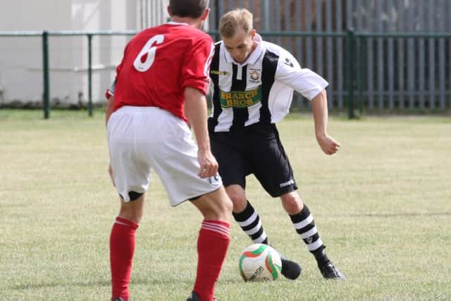 Sam Wilson (stripes) of Peterborough Northern Star in action against Rothwell Corinthains. Photo: Tim Gates.
