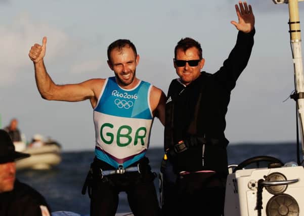 Great Britain windsurfer Nick Dempsey (left) and his coach celebrate winning the silver medal.