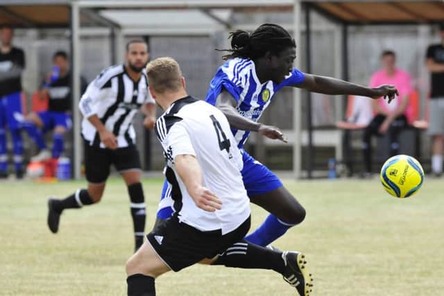 Ali Nyang (blue) of Peterborough Sports Reserves bursts past a Langtoft defender. Photo: Chris Lowndes.