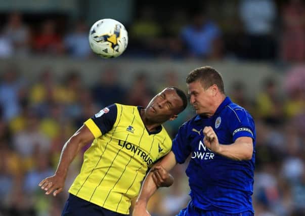 Oxford United's much-travelled striker Wes Thomas battles for possession of the ball in the air with Leicester City's Robert Huth during a pre-season friendly.