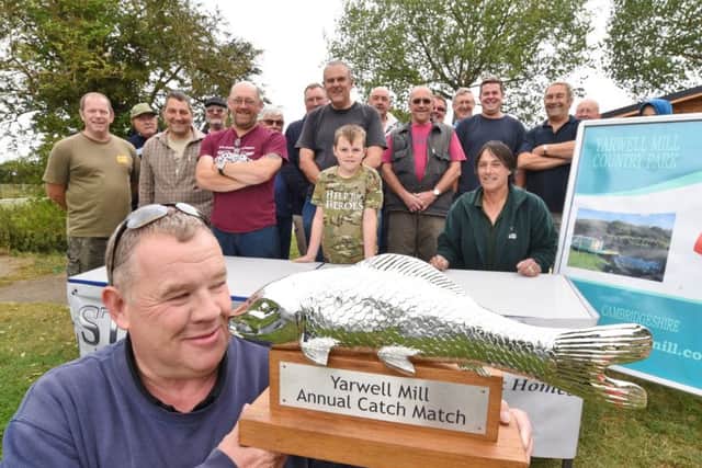 Howard Jones (event organiser) with the trophy for the winner  of the Yarwell Mill angling competition watched by entrants EMN-160820-181127009