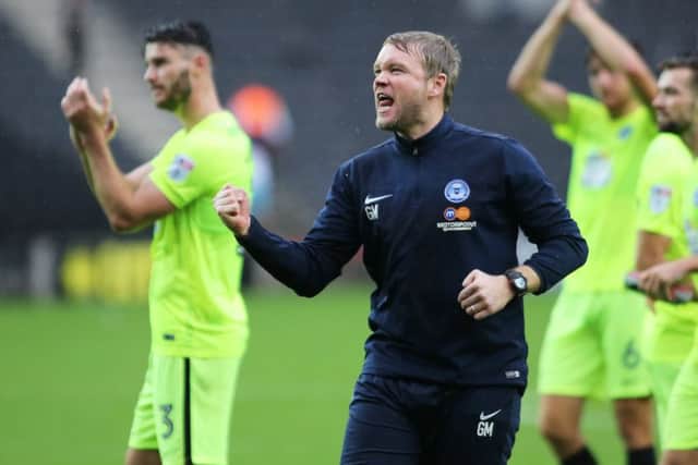 Posh boss Grant McCann celebrates victory at MK Dons in front of the travelling fans. Photo: Joe Dent/theposh.com.