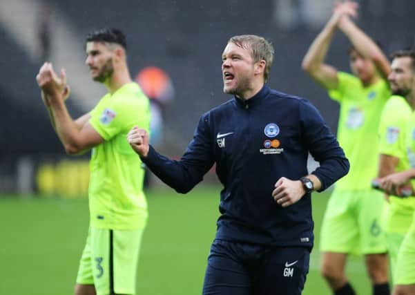 Posh boss Grant McCann celebrates victory at MK Dons in front of the travelling fans. Photo: Joe Dent/theposh.com.