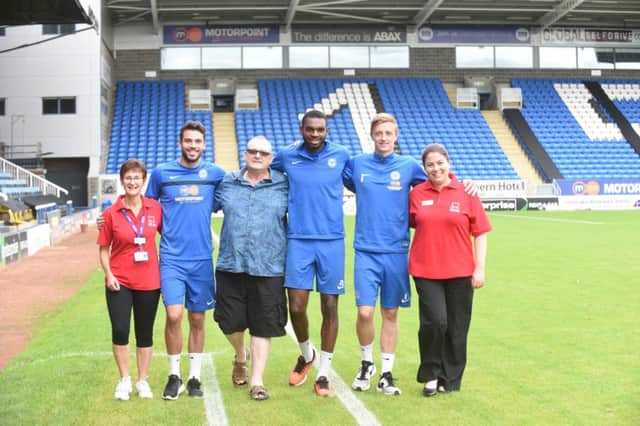 Marathon man Chris York with Debbie Beales and  Iona McAllister from CPFT with Posh players Brad Inman, Hayden White and Chris Forrester during his first lap of the Posh Ground. EMN-160709-155819009