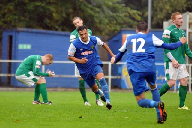 Cenk Acar (centre, blue) has just scored the winning goal for Spalding against Loughborough Dynamo. Photo: Tim Wilson.