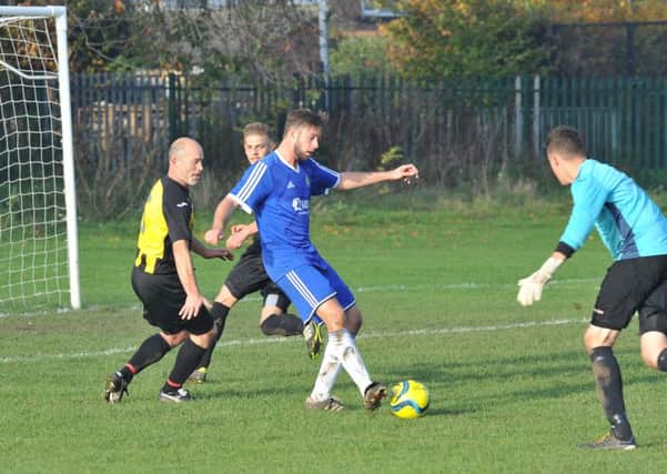 Gary Gibbs (blue) scored twice for Peterborough Sports Reserves at Thorney.