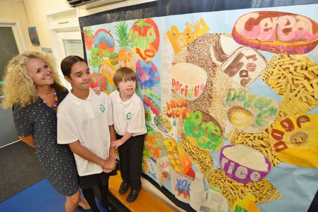Marshfield School teacher Alison Cavanagh with pupils  Maya Claydon and Louis Heppell looking at the healthy eating display which helped them win an award recently. EMN-160913-182300009