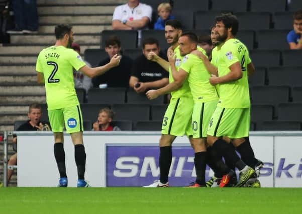 Andrew Hughes of Peterborough United (second from left) celebrates with team-mates after scoring the opening goal in a League One win over Milton Keynes last month. Picture: Joe Dent