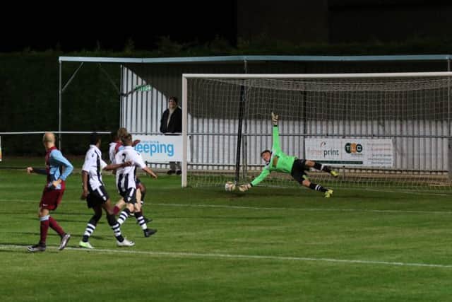 Dan Schiavi's shot is on its way past Peterborough Northern Star goalkeeper Dan George to make it 3-0 to Deeping Rangers. Photo: Tim Gates.