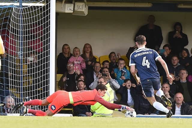 Posh goalkeeper Luke McGee dives on the ball after saving a penalty at Southend. Photo: David Lowndes.