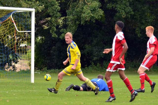 Marcus Parry (yellow) scores for Moulton Harrox against Peterborough Sports Reserves. Photo: Tim Wilson.