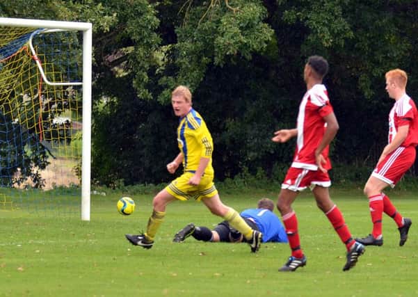 Marcus Parry (yellow) scores for Moulton Harrox against Peterborough Sports Reserves. Photo: Tim Wilson.
