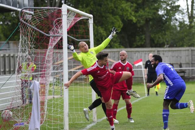 Avelino Vieira (blue) scores for Peterborough Sports in their 4-1 FA Cup win at Wisbech.