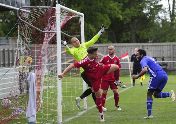 Avelino Vieira (blue) scores for Peterborough Sports in their 4-1 FA Cup win at Wisbech.