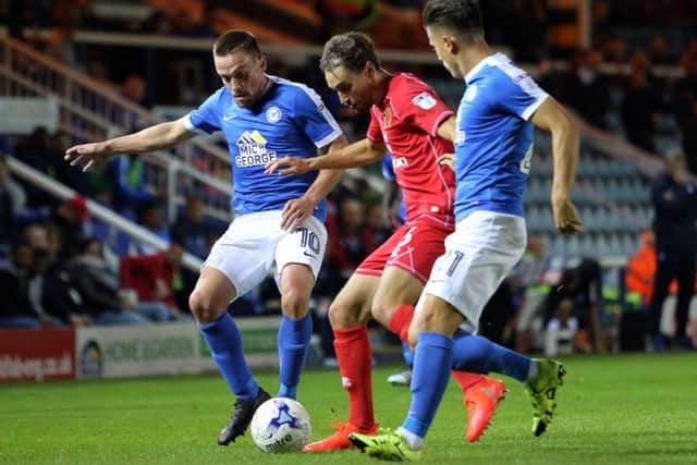 Posh substitutes Paul Taylor and Tom Nichols close down Ed Upson of MK Dons. Photo: Joe Dent/theposh.com.