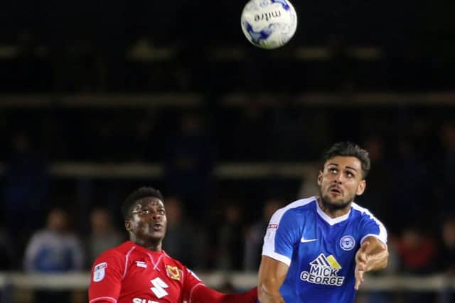 Posh centre-back Ryan Tafazolli challenges Kieran Agard of MK Dons for the ball. Photo: Joe Dent/theposh.com.