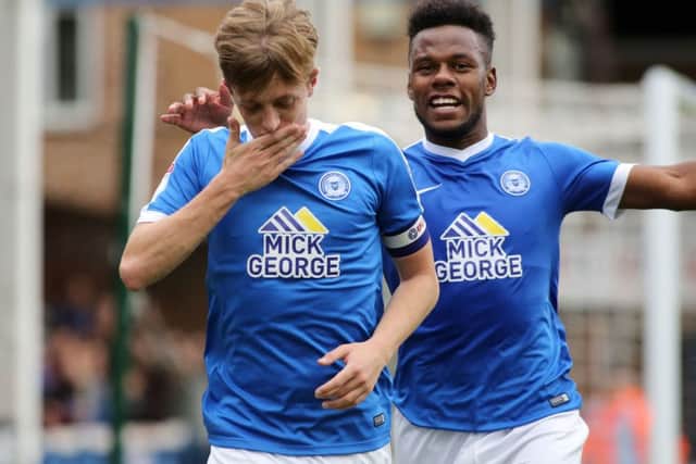 Shaquile Coulthirst is about to embrace Posh skipper Chris Forrester after the latter's goal against Bury. Photo: Joe Dent/theposh.com.