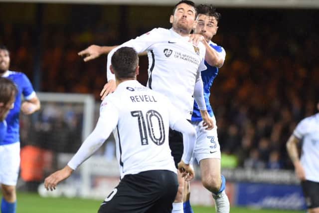 Posh full-back Andrew Hughes in an aerial duel against Northampton. Photo: David Lowndes.
