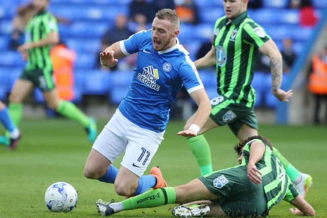 Marcus Maddison of Peterborough United is tackled by George Francomb of AFC Wimbledon  - Mandatory by-line: Peterborough United Football Club Ltd / PaperPix- 2016 - 16/17 - FOOTBALL - ABAX Stadium - Peterborough, Cambs - Peterborough United v AFC Wimbledon
