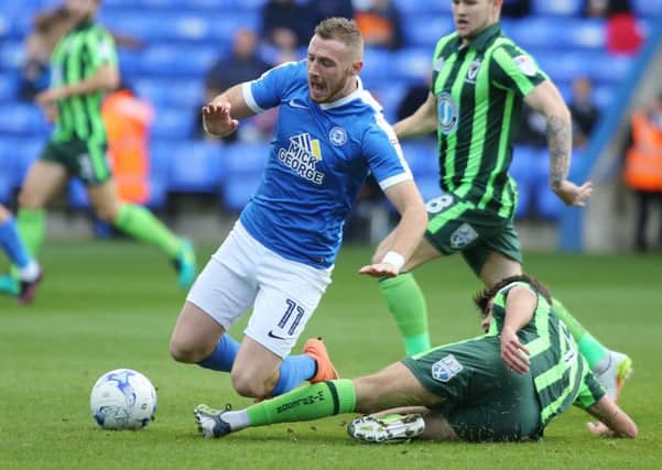 Marcus Maddison of Peterborough United is tackled by George Francomb of AFC Wimbledon  - Mandatory by-line: Peterborough United Football Club Ltd / PaperPix- 2016 - 16/17 - FOOTBALL - ABAX Stadium - Peterborough, Cambs - Peterborough United v AFC Wimbledon