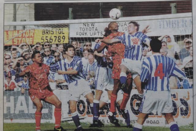 Roger Willis gets up well for Posh with Ken Charlery (left) waiting to pounce.