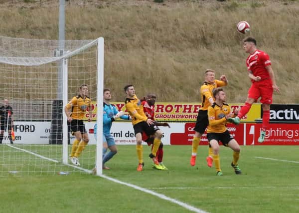 Ryan Grant (red) scored for Stamford AFC at Basford United. Photo: Geoff Atton.