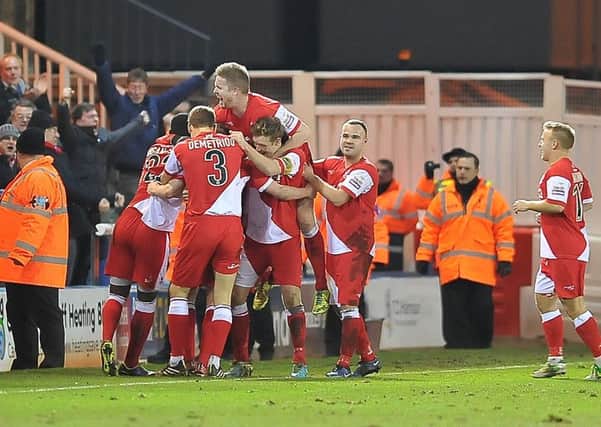 Kidderminster players celebrate an FA Cup goal at Posh.