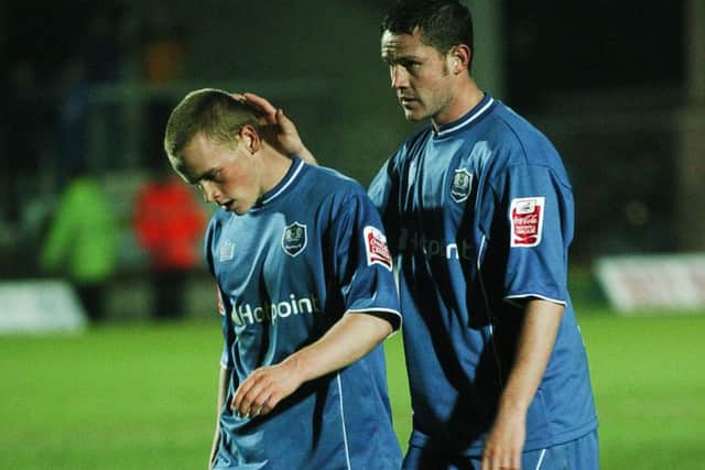 Posh players Jamie Day (left) and Mark Arber trudge off the pitch after an FA Cup defeat at Burton.