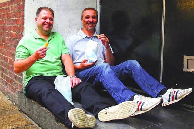Picture titled Eating Chips  Reunion Pic August 2016  School friends Martin Coulson (left) and Andy Randall were eating chips bought from the arcade which has now been replaced with Wilkinsons in Peterborough.. I think it must have been a Saturday and wed been to the chip shop. The chips were a bit like McDonalds fries and were always good, said Martin, who was a warehouse manager and is currently re-training. He is married with two children. Andy is a telematics engineer and is married with three children.