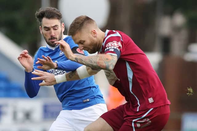 Michael Smith of Posh battles for possession with Chesham's Bruce Wilson. Photo: Joe Dent/theposh.com.