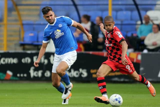 Ryan Tafazolli (blue) plays for Posh at Barnet.