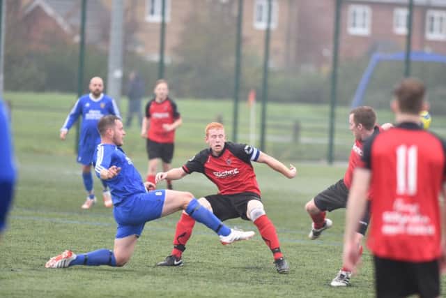 Stanground's Lloyd Mapes (blue) contests a loose ball with Netherton's Herbie Panting. Photo: David Lowndes.