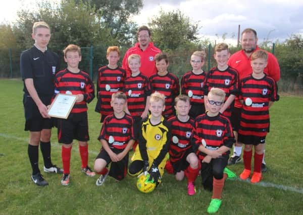 Park Farm Pumas Under 11s are pictured receiving on behalf of their club a framed certificate awarded by the Peterborough Referees Association for outstanding hospitality and attitude to match officials. Making the presentation is Peterborough RA member George Owens. Picture: RWT Photography