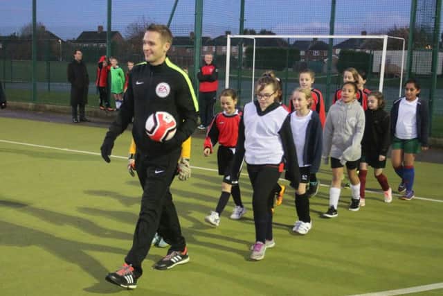 Craig Pawson leads the teams out at a mini-festival.