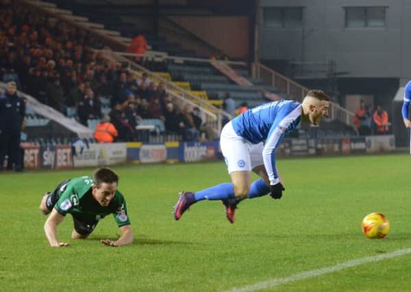 Marcus Maddison of Posh flies through the air after a Scunthorpe tackle. Photo: David Lowndes.