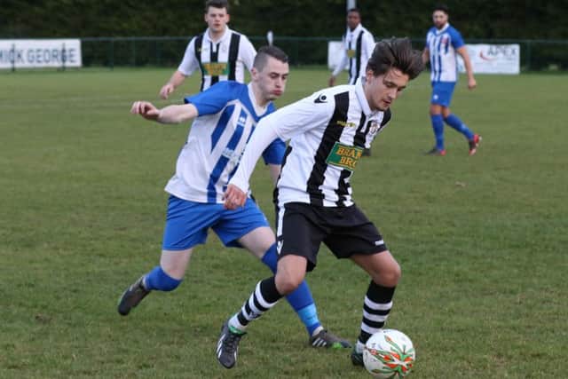 Kieran Blanchard (stripes) on the ball for Peterborough Northern Star against Harrowby. Photo: Tim Gates.