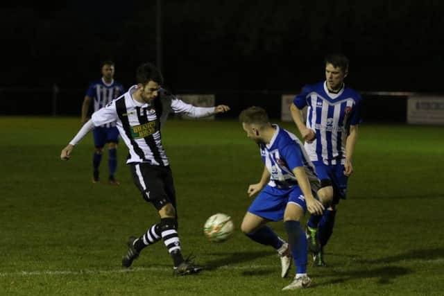 Top defender Matt Cox (stripes) in action for Peterborough Northern Star against Harrowby. Photo: Tim Gates.