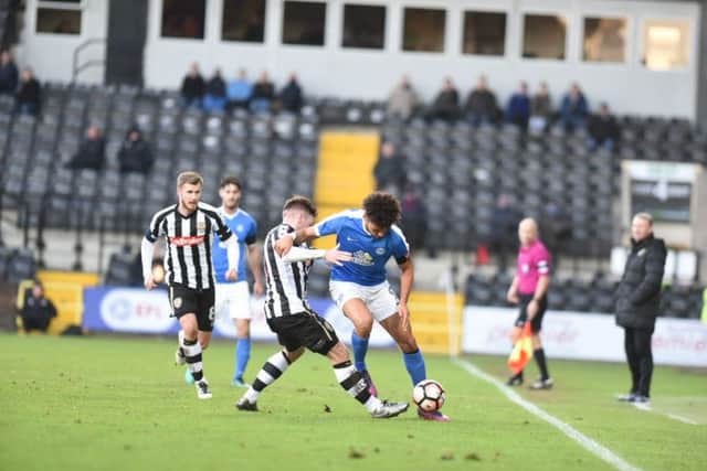 Posh striker Lee Angol is about to be challenged by Matt Tootle, in the incident that led to the former's red card. Photo: David Lowndes.